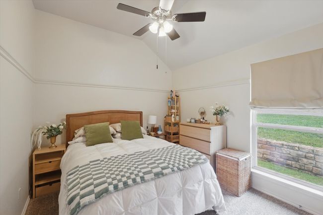 Bedroom with ceiling fan, light colored carpet, and lofted ceiling | Image 32