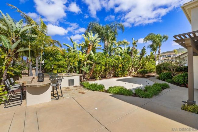 View to outdoor kitchen as well as sand pit area currently used as a bocce ball court - if younger kids, perfect place for a swing set | Image 37