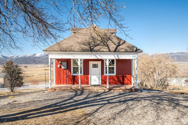 View of front of house featuring an outbuilding, a shingled roof, and a mountain view | Image 25
