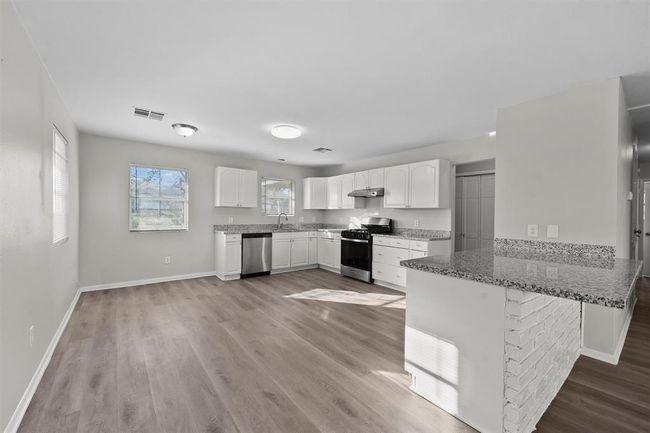 Bright and spacious kitchen with modern appliances, granite countertops, and ample counter space. | Image 6