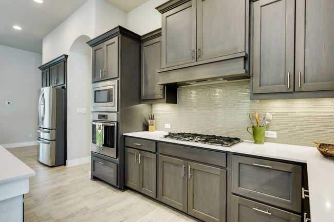 Kitchen featuring stainless steel appliances, light countertops, oversized island | Image 11
