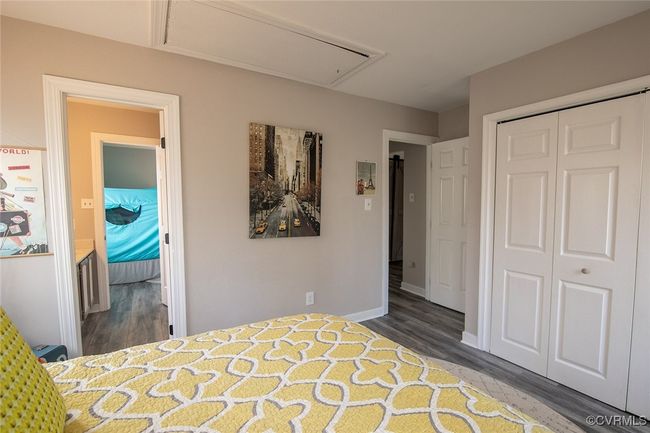 Unfurnished bedroom with a closet, baseboards, attic access, and wood finished floors | Image 19