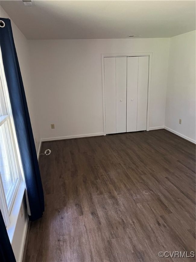 Unfurnished bedroom with dark wood-type flooring and a closet | Image 9