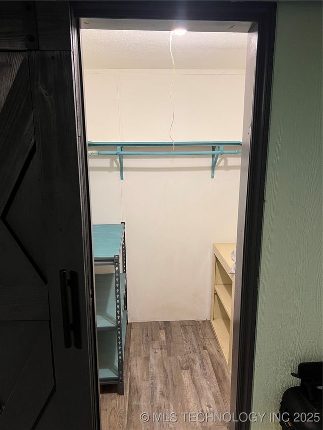 Walk in closet with wood finished floors | Image 18