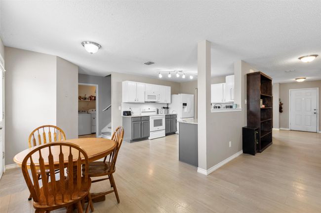 Dining space featuring a textured ceiling, light wood-style floors, and separate washer and dryer | Image 8