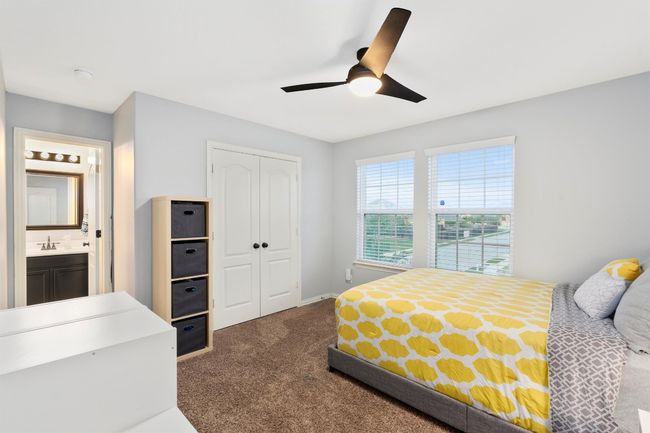 Bedroom with dark colored carpet, a closet, and a ceiling fan | Image 26