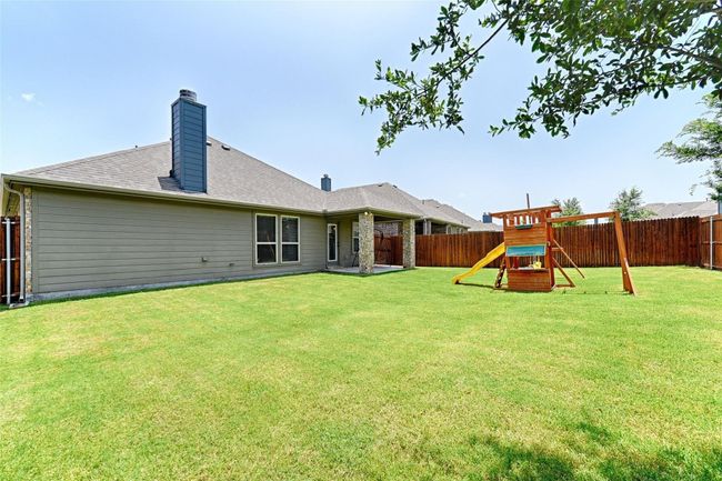 Rear view of house featuring a fenced backyard, a chimney, and a playground | Image 5