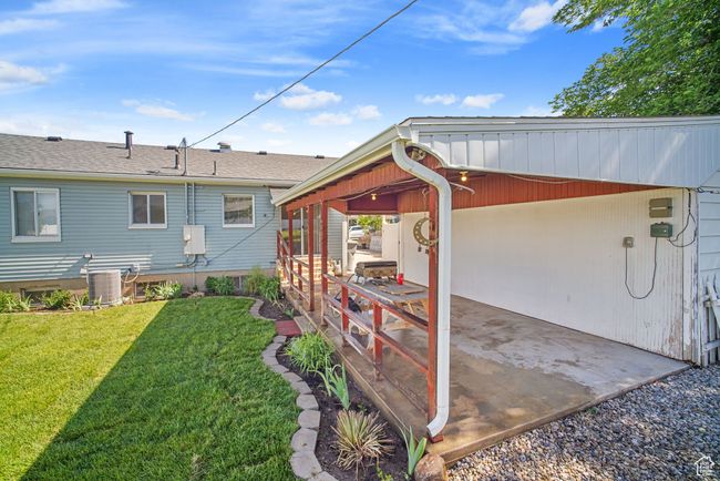 View of green lawn featuring central AC and an attached carport | Image 30
