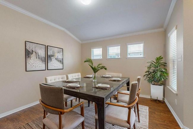 Dining room or bonus space at front of the home. Wood looking laminate flooring for easy upkeep. Crown molding and cute windows add to the charm of this home. This room is great as a formal dining or second living space and so much more. Virtually Staged picture. | Image 9