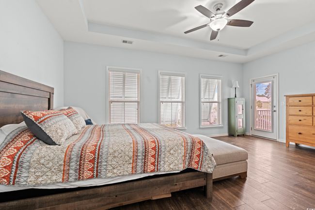 Master bedroom on the second level with a walk in closet, master bathroom, large windows, tray ceiling and a deck off of the bedroom overlooking the front. | Image 13
