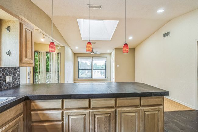 Kitchen with visible vents, tasteful backsplash, a wealth of natural light, and vaulted ceiling with skylight | Image 19