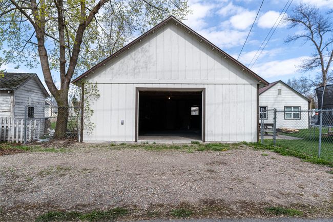 Detached garage featuring fence and dirt driveway | Image 33