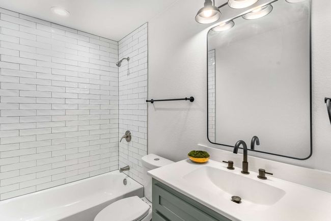 Full bathroom featuring toilet, vanity, and shower / washtub combination | Image 15