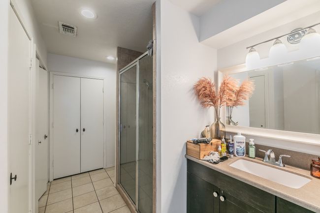 Unit 4900 Primary Bathroom featuring walk in shower, vanity, and tile patterned flooring | Image 16
