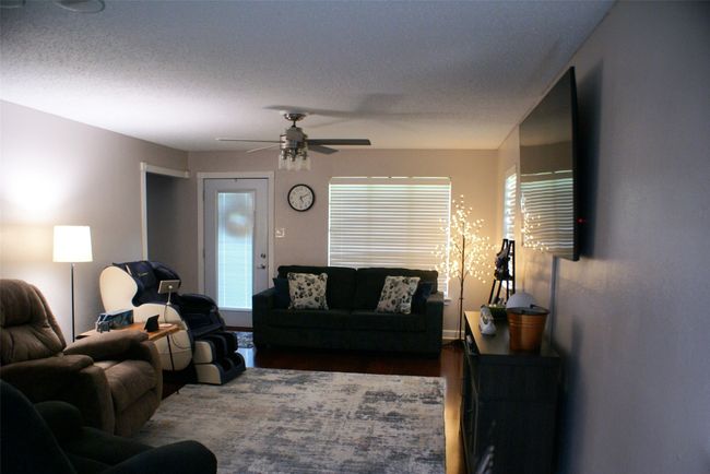 Living room with wood finished floors and a ceiling fan | Image 12