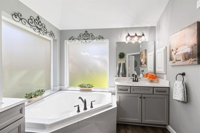You will be pampered in a luxurious primary bathroom that features a corner bathtub and large walk in closet. | Image 27