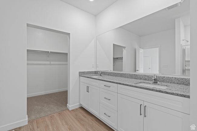 Bathroom with double vanity, wood finished floors, a spacious closet, and a sink | Image 6