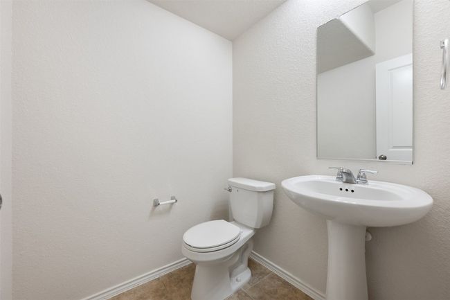 Half bathroom with toilet, tile patterned floors, and baseboards | Image 20