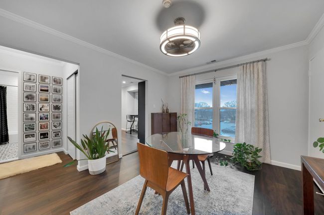 Dining space with baseboards, visible vents, ornamental molding, and wood finished floors | Image 13