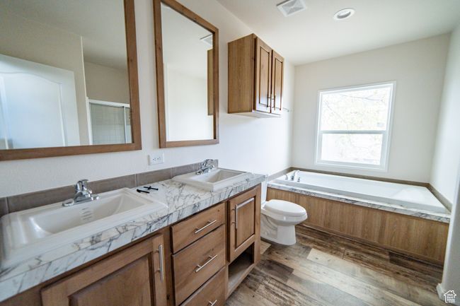 Bathroom featuring wood finished floors, visible vents, a garden tub, and a sink | Image 52