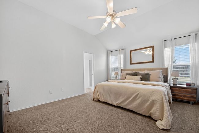 Carpeted bedroom with multiple windows, lofted ceiling, and ceiling fan | Image 12