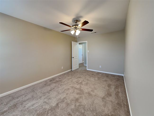 Carpeted empty room featuring ceiling fan and baseboards | Image 13