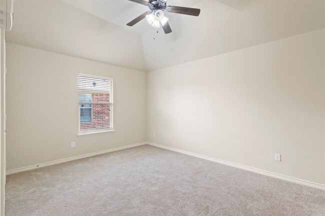 Spare room featuring carpet flooring, ceiling fan, baseboards, and lofted ceiling | Image 27