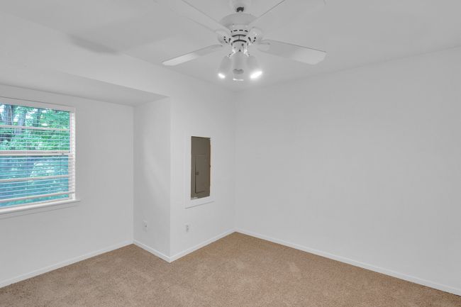 Spare room with baseboards, ceiling fan, electric panel, and light carpet | Image 18