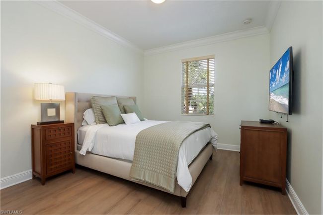 Bedroom with ornamental molding and light wood-style flooring | Image 17