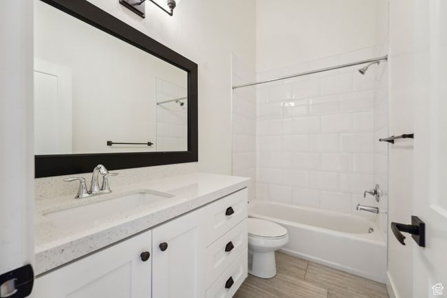 Bathroom featuring shower / bathtub combination, toilet, vanity, and wood finished floors | Image 36
