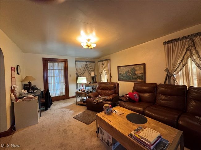 Living area with baseboards, arched walkways, and light colored carpet | Image 7