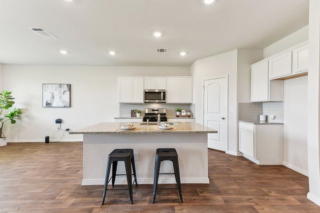 Heart of the Home: A spacious kitchen with granite countertops, sleek cabinetry, and a stylish backsplash. | Image 5
