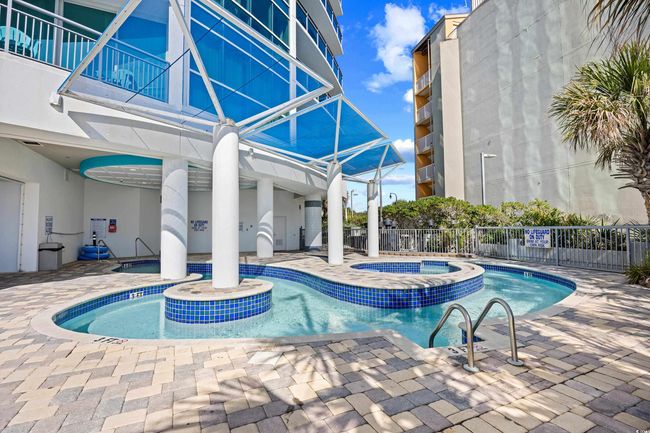 Community pool featuring a community hot tub, fence, and a patio | Image 34