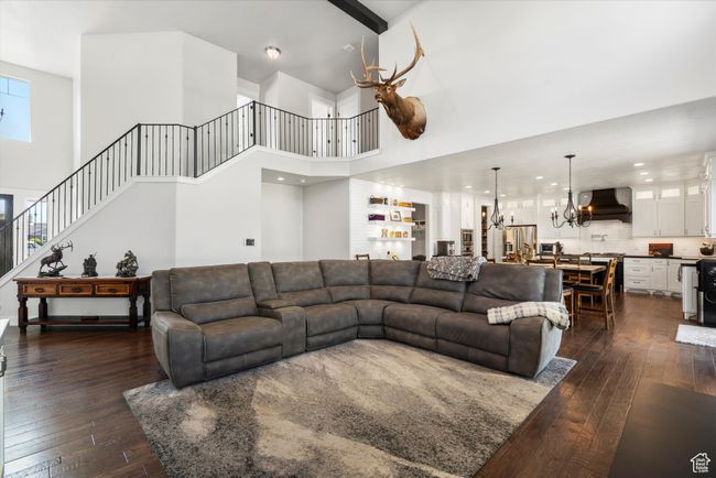 Living area with a high ceiling, a notable chandelier, and dark wood finished floors | Image 11