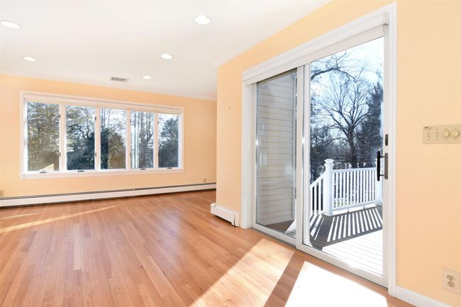 First Floor Family room featuring visible vents, crown molding, recessed lighting, light wood-style floors, and a baseboard radiator | Image 8
