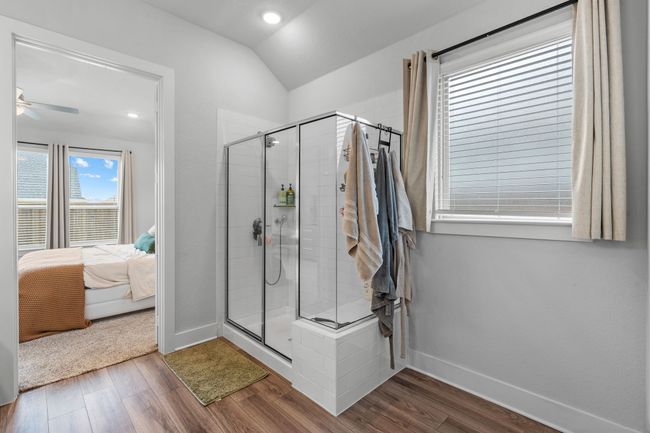 Bathroom featuring ensuite bath, dark wood finished floors, a stall shower, lofted ceiling, and recessed lighting | Image 26