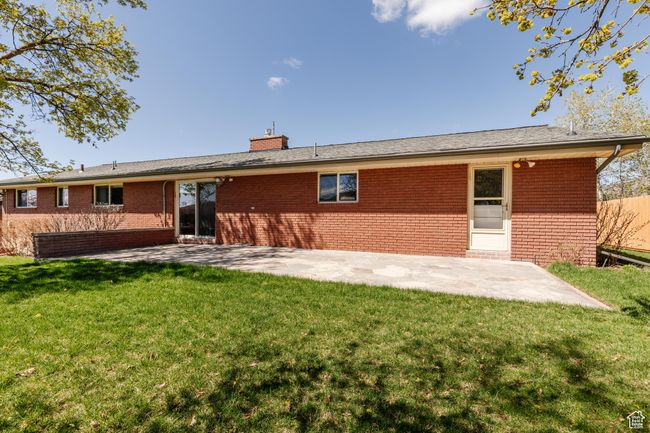 Rear view of house featuring brick siding, a yard, and a patio | Image 39