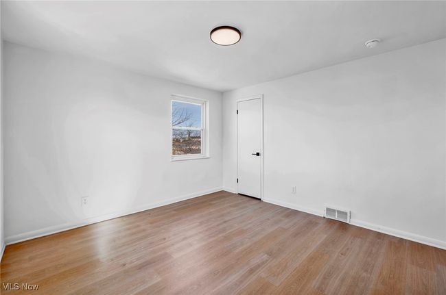Spare room with wood finished floors, baseboards, and visible vents | Image 17