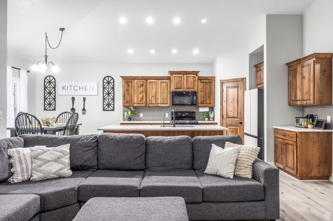 Living room with an inviting chandelier and light hardwood / wood-style floors | Image 11