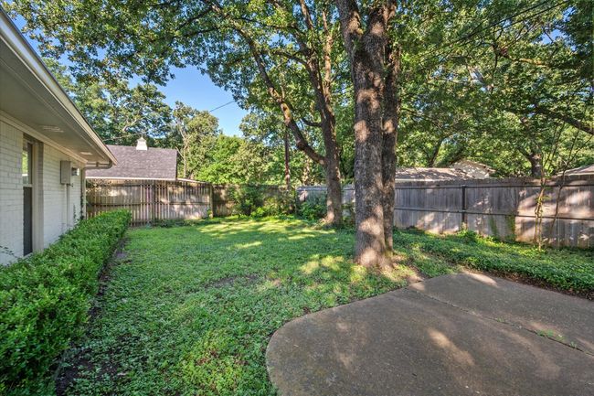 Fenced backyard with a patio area | Image 36