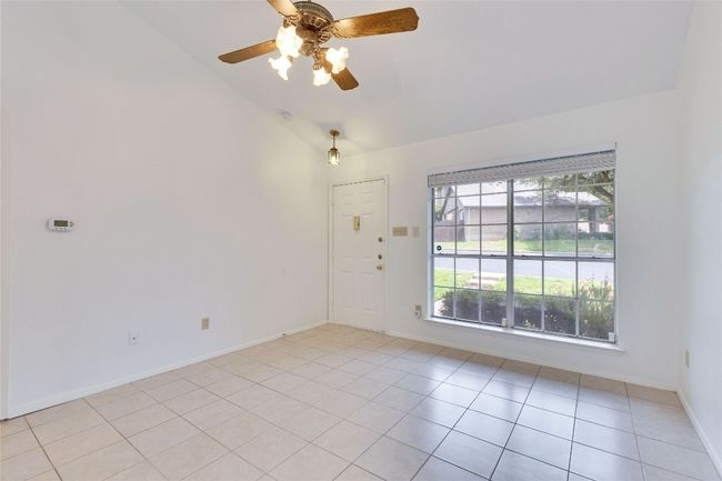 Spare room featuring a ceiling fan, light tile patterned floors, and high vaulted ceiling | Image 7