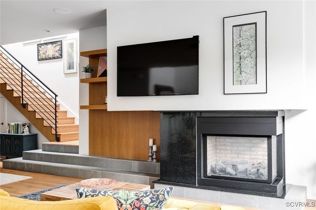 The gas fireplace and wood clad wall with built in shelves make quite a statement. | Image 6