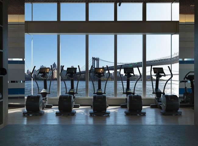 Gym with wood finished floors and a water view | Image 13