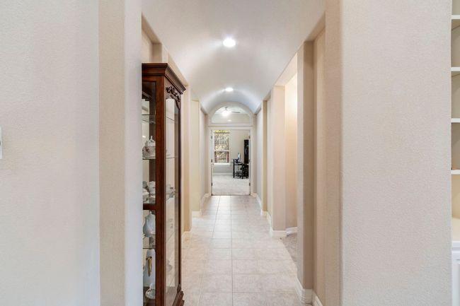 Hallway with light tile patterned floors and baseboards leading to 2 bedrooms | Image 19