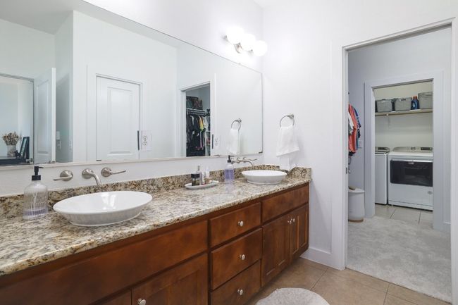 Full bath featuring tile patterned floors, washer and dryer, and a sink | Image 18