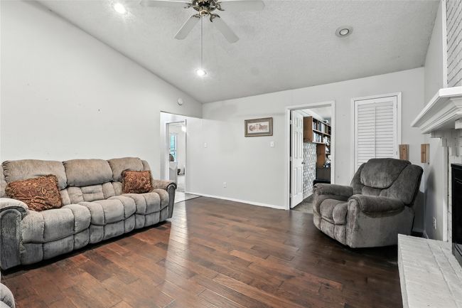 Living room with lofted ceiling, a ceiling fan, dark wood-style flooring, recessed lighting, and a textured ceiling | Image 14