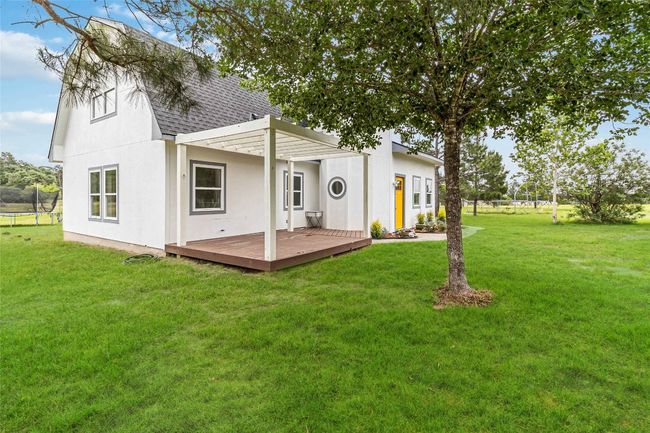 Back of property featuring a shingled roof, a lawn, and a wooden deck | Image 32