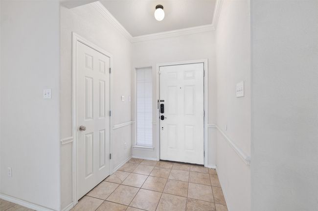 Foyer with light tile patterned floors, baseboards, and crown molding | Image 5