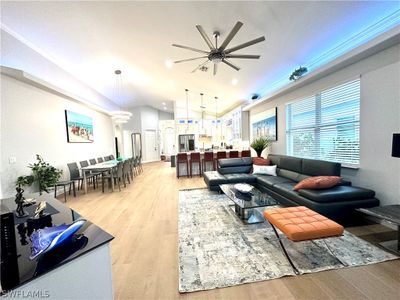 Living room with ceiling fan, light hardwood / wood-style flooring, and vaulted ceiling | Image 2