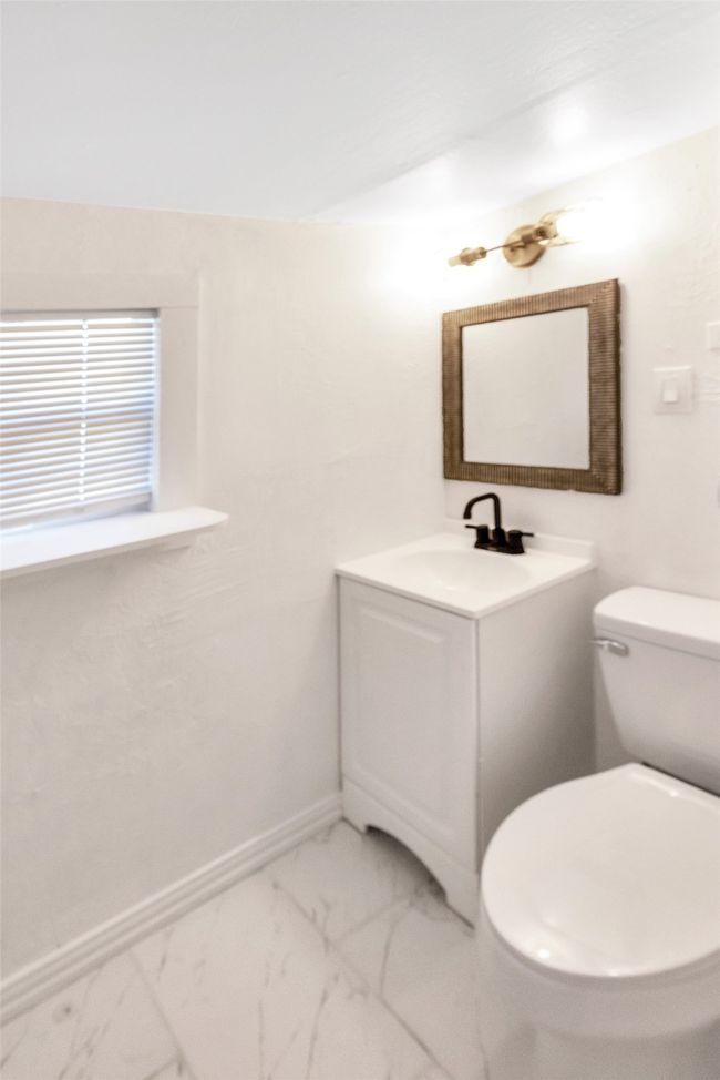 Half bath featuring vanity and marble look tile flooring | Image 18